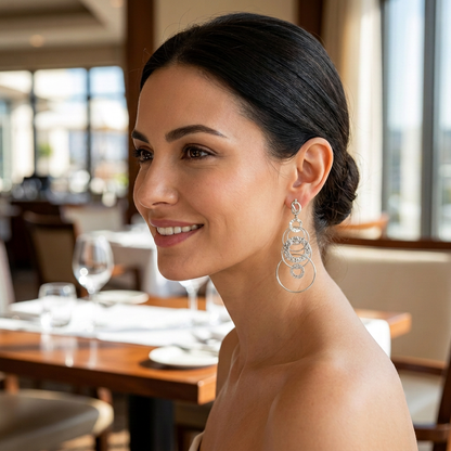 Modelka z wiszącym kolczykiem z połączonych kółek w srebrnym kolorze w restauracji