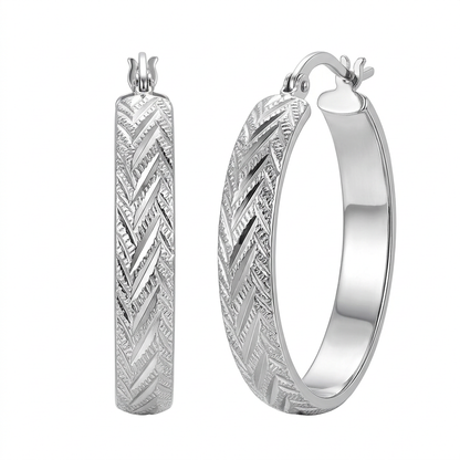 Para srebrnych kolczyków kółek z plecionym grawerowanym wzorem na białym tle